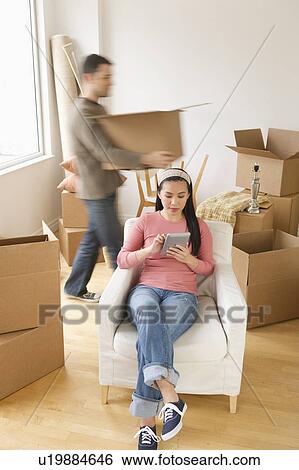 Man and woman unpacking things in new house View Large Photo Image Stock Photograph - Man and woman unpacking things in new house. Fotosearch