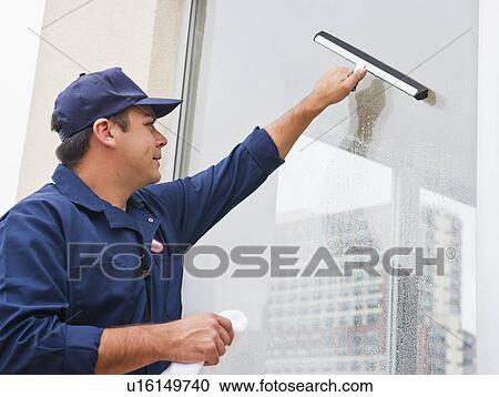 Stock Image - Man cleaning window. Fotosearch