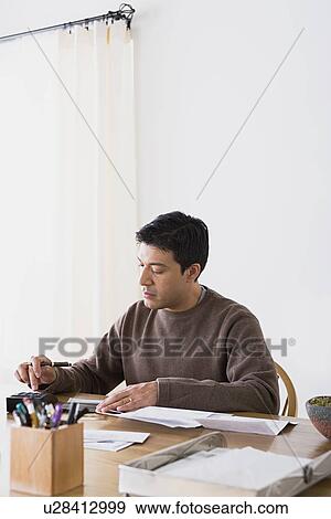 Man doing paperwork at home View Large Photo Image Stock Photo - Man doing paperwork at home. Fotosearch