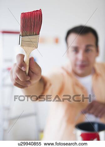 Stock Photography - Man holding paint brush. Fotosearch