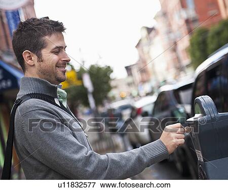 Man inserting coin to parking meter View Large Photo Image Stock Photo - Man inserting coin to parking meter. Fotosearch