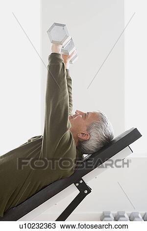 Man lifting dumbbells View Large Photo Image Stock Image - Man lifting dumbbells. Fotosearch