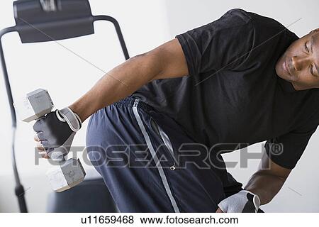 Stock Photo - Man lifting dumbbells. Fotosearch