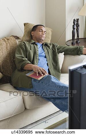 Stock Photography - Man napping on sofa. Fotosearch