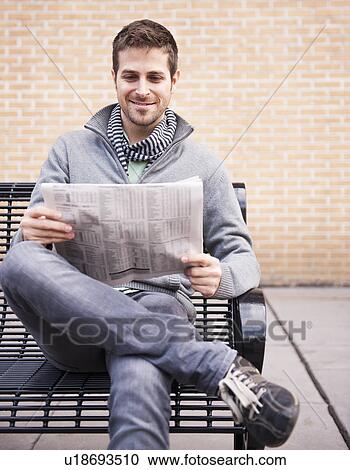 Man on bench reading newspaper View Large Photo Image Stock Image - Man on bench reading newspaper. Fotosearch