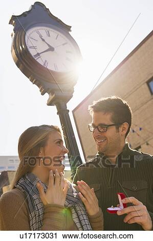 Stock Image - Man proposing to woman on street. Fotosearch