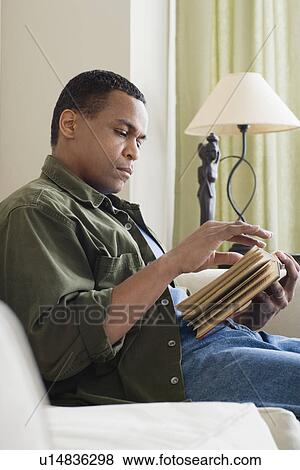 Man reading book at home View Large Photo Image Stock Photo - Man reading book at home. Fotosearch