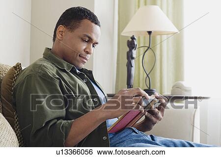 Stock Photograph - Man reading book at home. Fotosearch