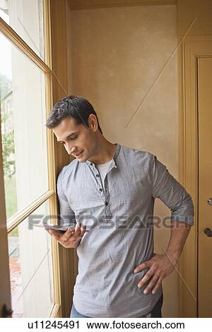 Stock Image - Man reading e-book at home. Fotosearch