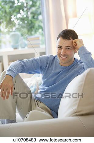 Man relaxing on sofa View Large Photo Image Stock Image - Man relaxing on sofa. Fotosearch