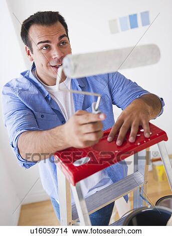 Man standing on ladder with paint roller View Large Photo Image Picture - Man standing on ladder with paint roller. Fotosearch