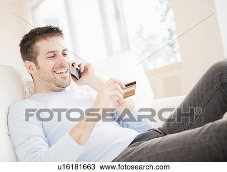 Man talking on mobile and holding credit card View Large Photo Image Stock Image - Man talking on mobile and holding credit card. Fotosearch