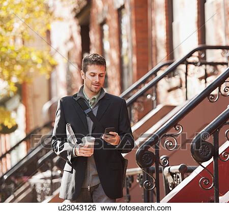 Man walking with mobile phone and coffee View Large Photo Image Stock Photograph - Man walking with mobile phone and coffee. Fotosearch