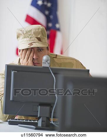 Picture - Man wearing military uniform looking on monitor. Fotosearch