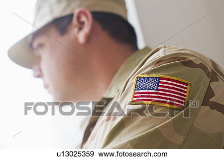 Stock Photo - Man wearing military uniform looking through window. Fotosearch