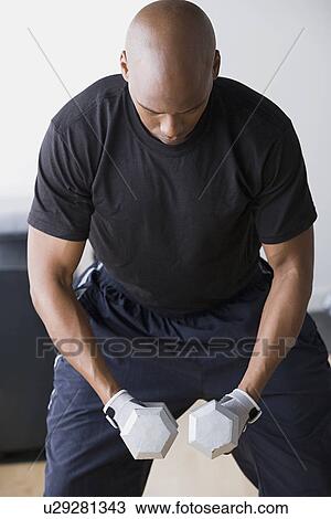 Stock Image - Man weighting dumbbells. Fotosearch