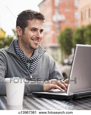 Man with laptop sitting in outdoor cafe View Large Photo Image Stock Image - Man with laptop sitting in outdoor cafe. Fotosearch