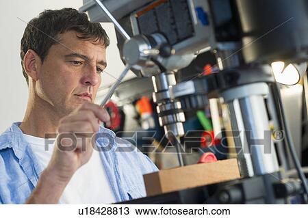 Mature man drilling in workshop View Large Photo Image Stock Image - Mature man drilling in workshop. Fotosearch