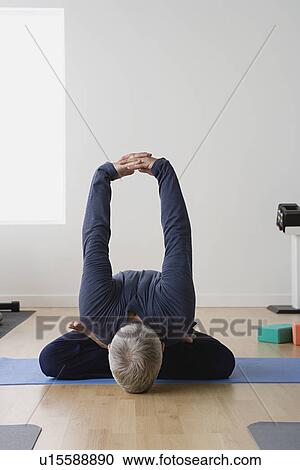 Mature man practicing yoga on mat View Large Photo Image Stock Image - Mature man practicing yoga on mat. Fotosearch