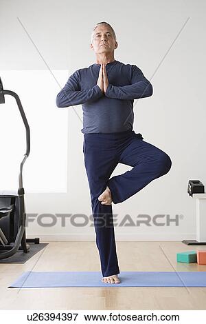 Mature man practicing yoga on mat View Large Photo Image Stock Photo - Mature man practicing yoga on mat. Fotosearch