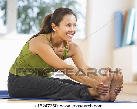 Mid adult woman training with dumbbell View Large Photo Image Stock Image - Mid adult woman training with dumbbell. Fotosearch