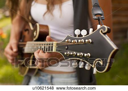 Stock Photo - Midsection of woman playing guitar. Fotosearch