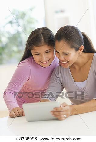 Mother and daughter (10-11) using digital tablet View Large Photo Image Stock Photograph - Mother and daughter (10-11) using digital tablet. Fotosearch