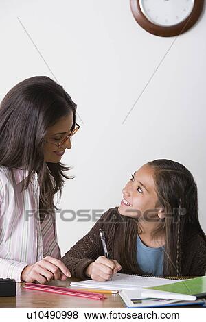 Mother doing homework with daughter (10-11) View Large Photo Image Stock Photo - Mother doing homework with daughter (10-11). Fotosearch