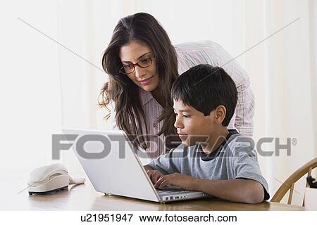 Stock Photo - Mother doing homework with son (10-11). Fotosearch