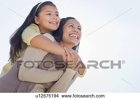 Picture - Mother giving piggyback ride to her daughter (10-11). Fotosearch
