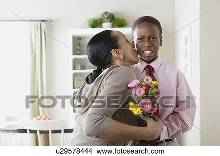 Picture - Mother kissing Son (12-13) holding bouquet. Fotosearch