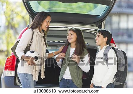 Stock Image - Mother with son (12-13) and daughter (10-11) . Fotosearch