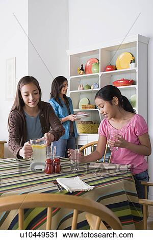 Mother with two daughters (8-9, 10-11) cleaning from table View Large Photo Image Stock Image - Mother with two daughters (8-9, 10-11) cleaning from table. Fotosearch