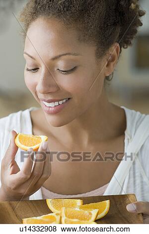 Portrait of attractive woman eating orange View Large Photo Image Stock Photo - Portrait of attractive woman eating orange. Fotosearch