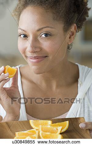 Portrait of attractive woman eating orange View Large Photo Image Stock Photography - Portrait of attractive woman eating orange. Fotosearch
