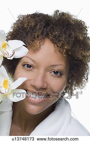 Stock Image - Portrait of attractive woman with tropical flowers. Fotosearch