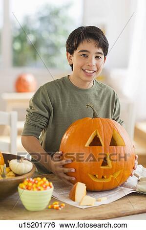 Portrait of boy (12-13) holding Jack o lantern View Large Photo Image Stock Photograph - Portrait of boy (12-13) holding Jack o lantern. Fotosearch