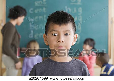 Stock Photo - Portrait of boy (6-7) with schoolmates in background. Fotosearch