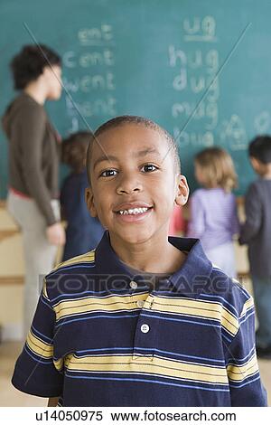 Stock Photography - Portrait of boy (6-7) with schoolmates in background. Fotosearch