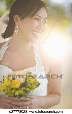 Stock Photo - Portrait of bride holding bouquet. Fotosearch