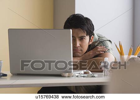 Stock Photo - Portrait of businessman looking at laptop. Fotosearch