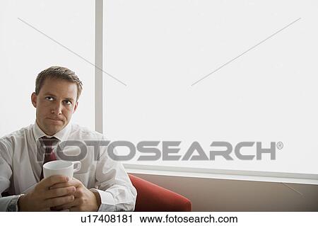 Portrait of businessman sitting with mug View Large Photo Image Stock Image - Portrait of businessman sitting with mug. Fotosearch