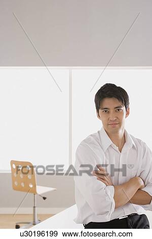 Portrait of businessman standing with arms crossed View Large Photo Image Stock Photo - Portrait of businessman standing with arms crossed. Fotosearch