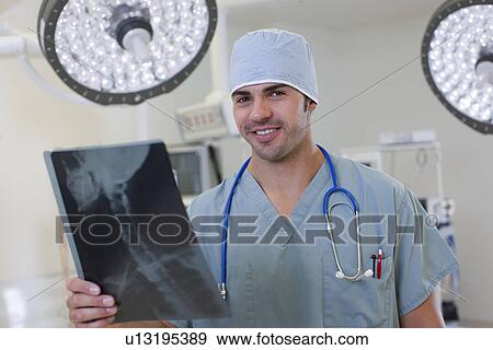 Stock Photo - Portrait of doctor looking at x-ray. Fotosearch