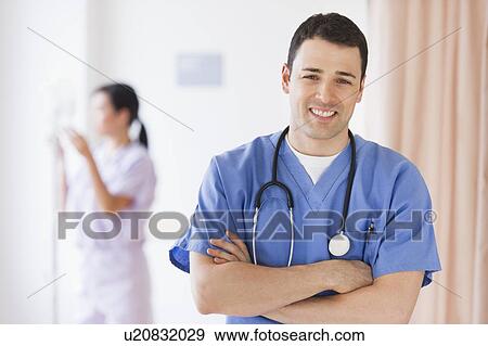 Stock Photo - Portrait of doctor, nurse in background. Fotosearch