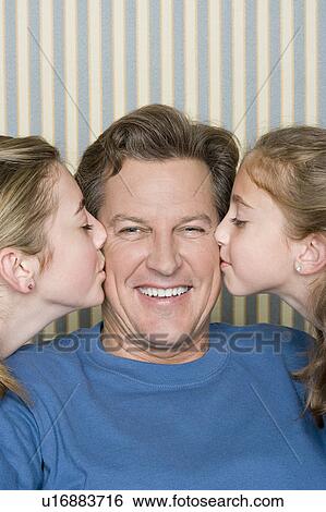 Stock Photograph - Portrait of father being kissed by two girls (8-9, 14-15) . Fotosearch