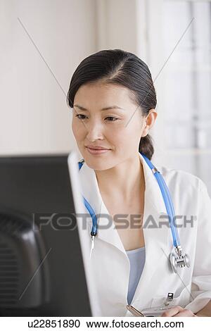Portrait of female doctor working by computer View Large Photo Image Stock Image - Portrait of female doctor working by computer. Fotosearch