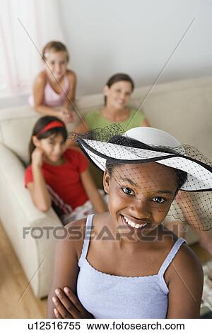 Stock Photography - Portrait of girl (10-11) wearing hat with veil at slumber party. Fotosearch