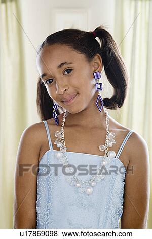 Stock Photo - Portrait of girl (10-11) wearing elegant clothes and jewelry. Fotosearch