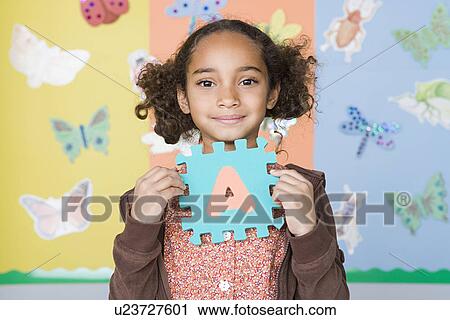 Portrait of girl (6-7) holding letter A View Large Photo Image Stock Image - Portrait of girl (6-7) holding letter A. Fotosearch